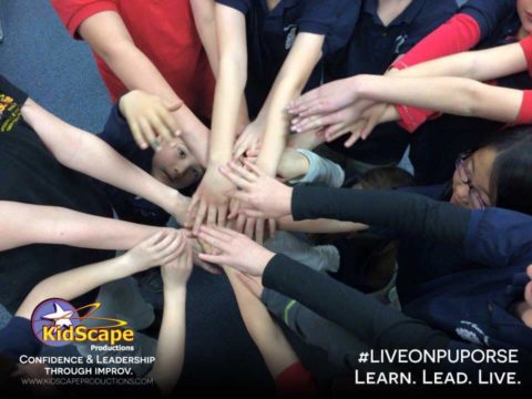 a group of people standing in a circle with their hands together