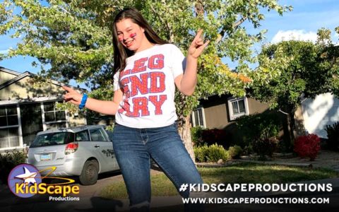 a girl in jeans and a t - shirt is dancing outside