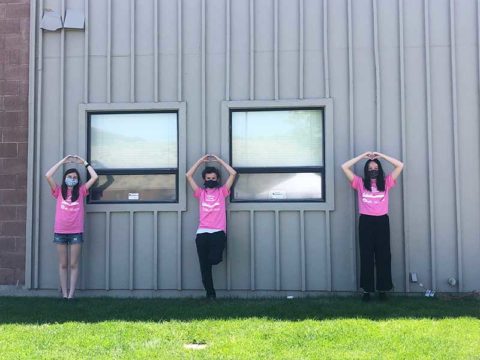 three women in pink shirts standing next to each other