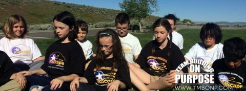 a group of young people sitting on the grass